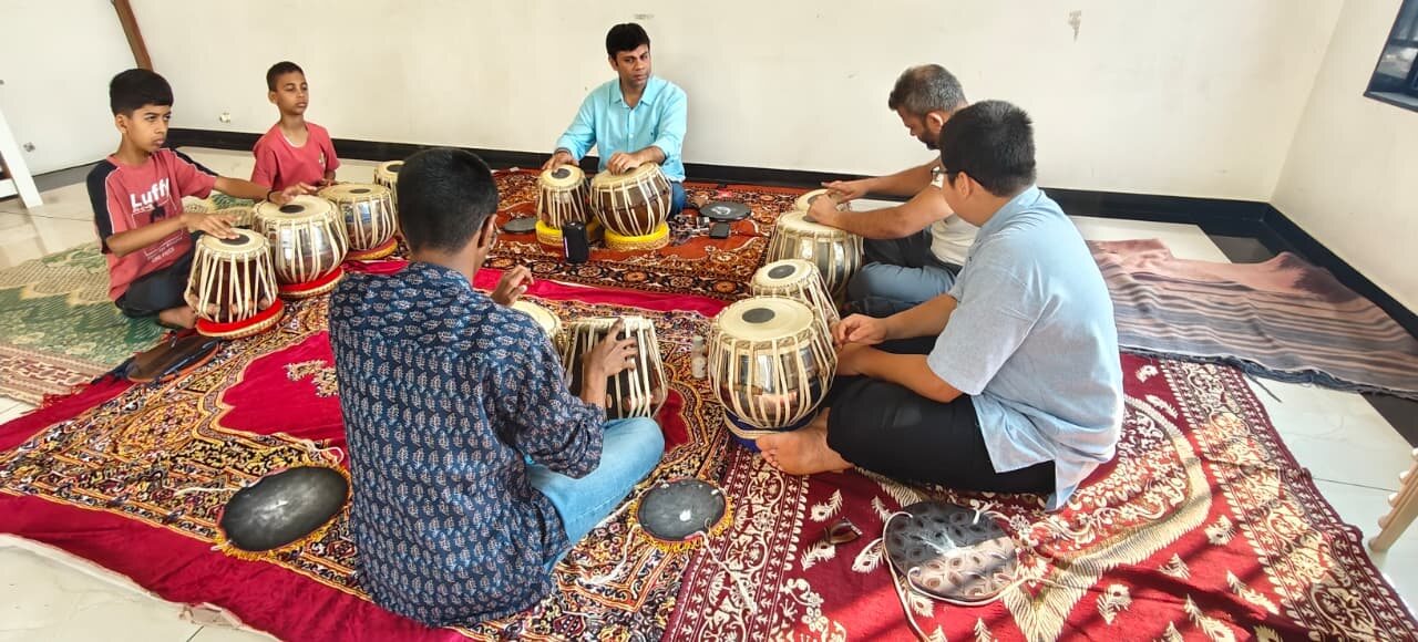 Rohit Mujumdar teaching a group of students around the tabla